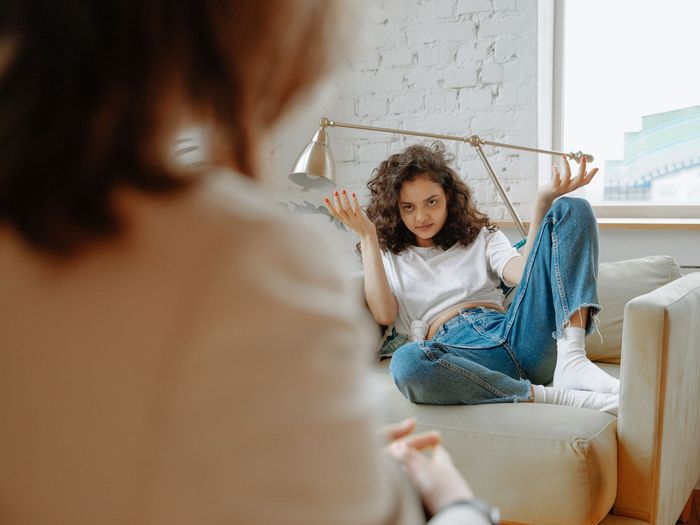 A therapist talks with a teenager in a calm, softly lit office